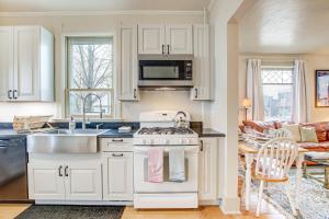 a kitchen with white cabinets and a stove top oven at Lovely Elkhart Lake Apartment - Walk to Town! in Elkhart Lake