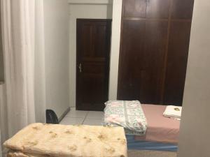 a small room with two beds and a door at Belo Horizonte - Espaço reservado para 5 pessoas in Belo Horizonte