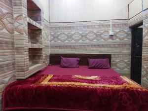 een slaapkamer met een groot bed met paarse kussens bij Annu Bhai sewa sadan in Mathura