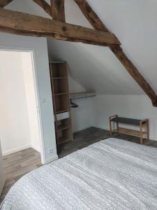 - une chambre avec un lit et une étagère dans l'établissement Dépendance au charme local, à Saint-Carné