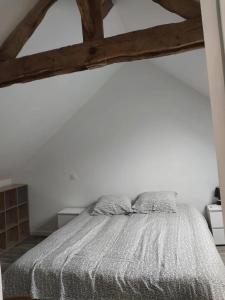 - une chambre blanche avec un lit dans l'établissement Dépendance au charme local, à Saint-Carné