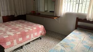 a room with two beds and a window at Casa Itaguá in Ubatuba