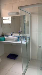 a bathroom with a sink and a glass shower at Casa Itaguá in Ubatuba