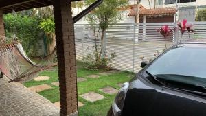 a car parked in a yard next to a hammock at Casa Itaguá in Ubatuba