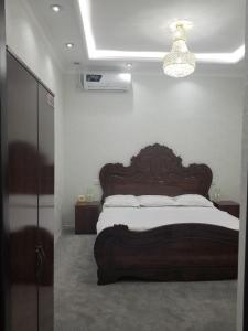 1 dormitorio con 1 cama grande y cabecero de madera en HOTEL OTA ABDUSALOM, en Samarkand