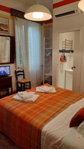 una camera da letto con un letto e due asciugamani di Tre Gigli Firenze BB, 5 minutes from station, via Palazzuolo 55 a Firenze