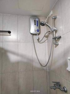 een douche in een badkamer met een telefoon aan de muur bij 10F Central location & Near Airport in Davao City