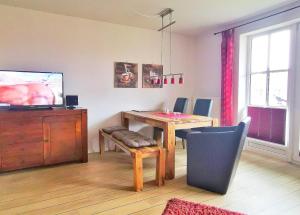 a living room with a dining room table and a television at Apartmentvermittlung Mehr als Meer - Objekt 60 in Niendorf