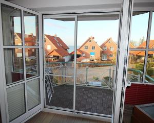 une véranda avec portes coulissantes en verre dans l'établissement Apartmentvermittlung Mehr als Meer - Objekt 60, à Niendorf