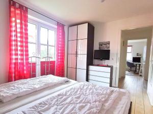 - une chambre avec un lit, une télévision et une fenêtre dans l'établissement Apartmentvermittlung Mehr als Meer - Objekt 60, à Niendorf
