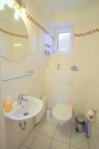 a white bathroom with a sink and a toilet at Apartmentvermittlung Mehr als Meer - Objekt 60 in Niendorf