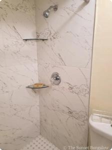 a bathroom with a shower with white marble at The Sunset Bungalow in Naples