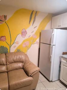 a kitchen with a couch next to a refrigerator at The Sunset Bungalow in Naples