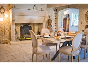 a dining room with a table and chairs and a fireplace at Le Mas des Aires - Chambres d'Hôtes - Blauzac -Uzès - Pont du Gard in Blauzac
