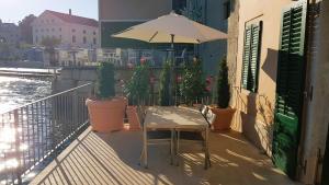 stół z parasolem na balkonie z roślinami w obiekcie Apartment Casa Marea w Rovinj