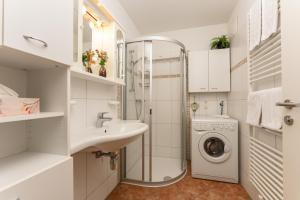 uma casa de banho com um lavatório e uma máquina de lavar roupa em Ferienwohnung Ulli by Schladming-Appartements em Schladming