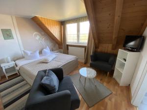 a bedroom with a bed and a couch and a tv at Aparthotel " Zur Müritz" in Rechlin