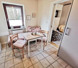 a dining room with a table and chairs in a room at Obj. 45* kleine, moderne FeWO 2 Pers. - nur 300 m zum Strand, W-LAN, Balkon in Häven