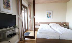 a bedroom with a bed and a flat screen tv at Obj. 45* kleine, moderne FeWO 2 Pers. - nur 300 m zum Strand, W-LAN, Balkon in Häven