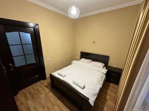 a bedroom with a bed with two white towels on it at Comfortable House the city centr in Kutaisi