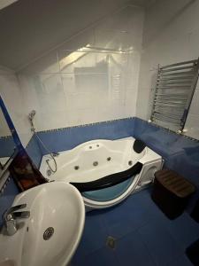 a bathroom with a bath tub and a sink at Comfortable House the city centr in Kutaisi