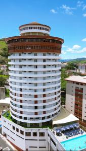 - un grand bâtiment avec une piscine en face dans l'établissement Panorama Hotel, à Águas de Lindóia