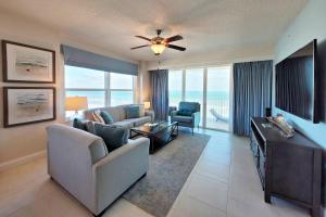 a living room with a couch and a ceiling fan at Aruba Condo Unit #1102 in Daytona Beach Shores
