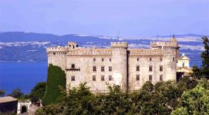 ein Schloss auf einem Hügel neben dem Wasser in der Unterkunft La Casa di Niky in Bracciano