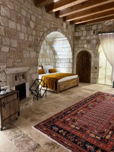 a bedroom with a bed and a stone wall at Chakra Special Caves in Urgup