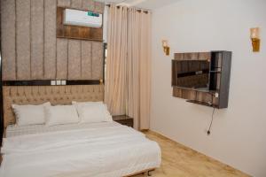 una camera con un letto bianco e una finestra di Dabras Homes a Kaduna