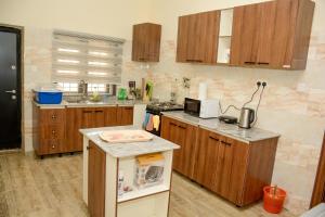 eine Küche mit Holzschränken und einer Arbeitsplatte in der Unterkunft Dabras Homes in Kaduna