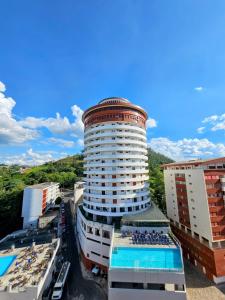 a large building with a swimming pool next to some buildings at Panorama Hotel in Águas de Lindoia