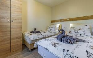 two beds in a bedroom with two swans on them at Mobile Homes Rocco 2 in Banjole +40 photos