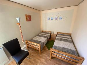 Habitación con 2 camas y una silla. en Aparthotel " Zur Müritz" en Rechlin