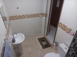 a bathroom with a shower and a sink and a toilet at Pousada Doce Lar in Itatiba