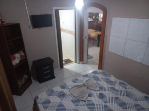 a bedroom with a bed and a mirror and a room at Pousada Doce Lar in Itatiba