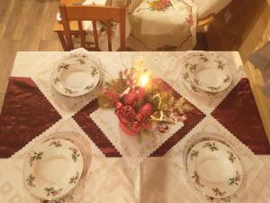 a table with three plates and a candle on it at Noclegi Żurawin in Lutowiska