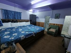 a bedroom with a bed with a blue comforter at KDol Residency in Darjeeling