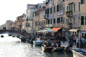 a group of people on boats in a canal with buildings at Casa Elia in Venice