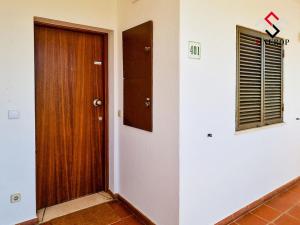 um corredor com uma porta de madeira e uma janela em Apartamento T1 - Valmangude em Albufeira