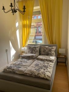 a bedroom with a bed and a window with yellow curtains at Gemütlicher Altbau in zentraler Lage Wiesbaden in Wiesbaden