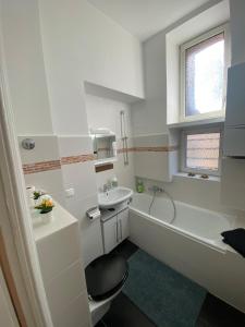 biała łazienka z wanną, toaletą i umywalką w obiekcie Gemütlicher Altbau in zentraler Lage Wiesbaden w mieście Wiesbaden