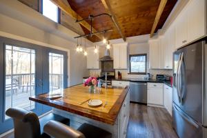 a kitchen with a wooden table and a refrigerator at Spacious Rockford Retreat Walk Downtown! in Rockford