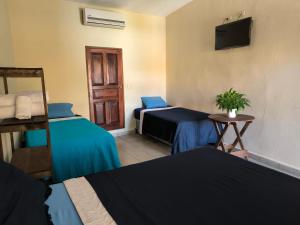 a hotel room with two beds and a tv at Hotel y Restaurante Casa Jardines in San Benito