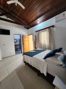 a bedroom with a bed and a wooden ceiling at La Bella Suítes in Ilhabela
