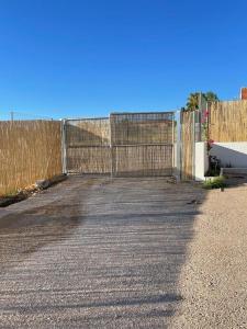 a gate on a road next to a fence at La Casita Rural in La Carlota