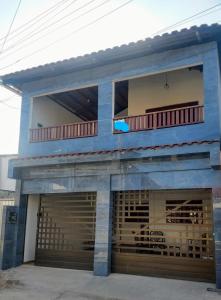 um edifício azul com uma garagem com um carro estacionado em Casa Mar Azul em Pitimbu