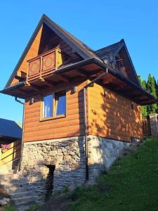 uma casa de madeira com uma varanda em cima em Chatka pod Lubaniem em Ochotnica Dolna