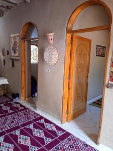 Desert Rose Guesthouse في الأقصر: غرفة بها باب وسجادة على الأرض