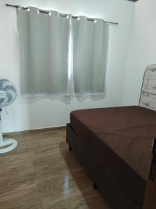 een slaapkamer met een bed met een gordijn en een ventilator bij Casa Mar Azul in Pitimbu